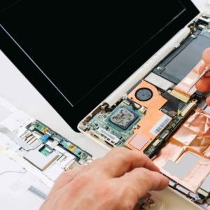 technicien informatique qui démonte un ordinateur portable